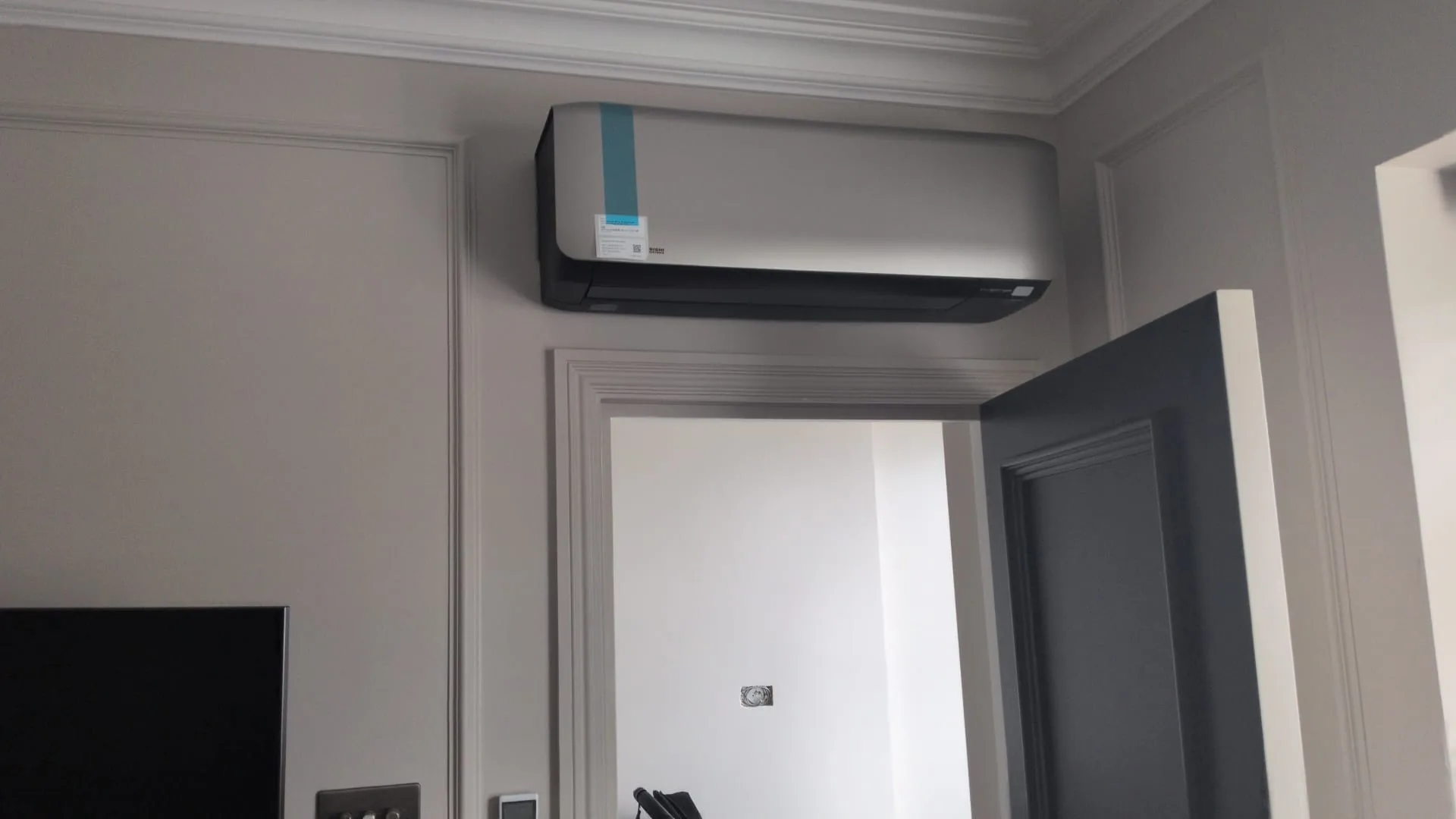 Wall-mounted split air conditioning unit installed in an elegant London living room